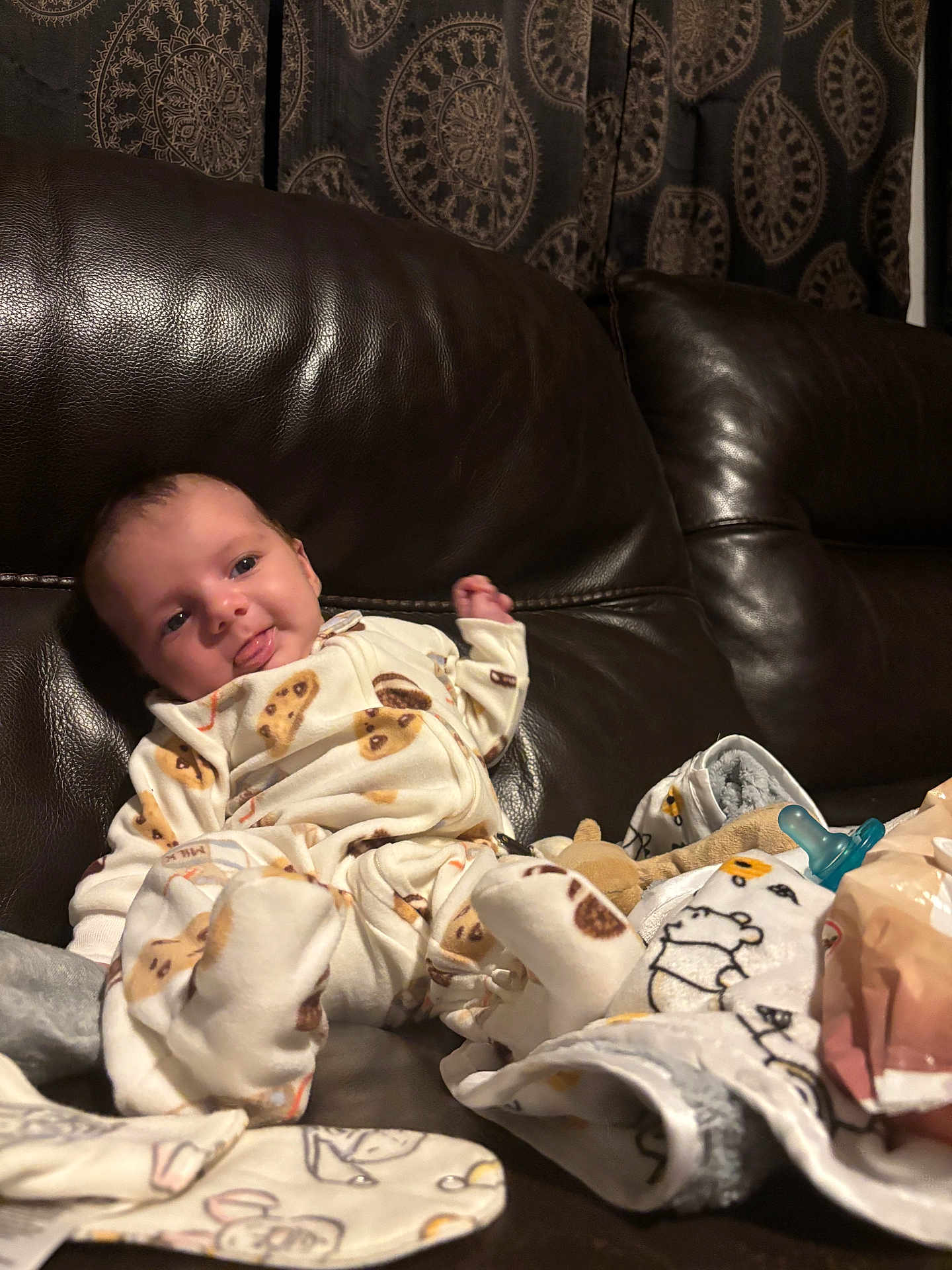 Jamaryon is registered to the contest to win money with this photo: baby, infant, pajamas, couch, leather, blanket, pacifier, tongue, playful, indoors, curtain, pattern, cozy, smiling, child, soft, relaxing, furniture, portrait, cute