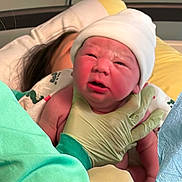 Alannah joined the competition — help win amazing prizes! newborn, baby, hospital, gloved_hand, person, hat, bed, blanket, medical, infant, healthcare, parent, skin, face, expression, holding, clothing, adult, indoor, care