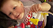 Asher joined the competition — help win amazing prizes! toddler, child, bed, pillow, toy, plush, watermelon, shirt, spiderman, colorful, smiling, indoor, blanket, happy, person, face, hand, clothing, cute, lying_down