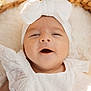 baby, infant, white_clothing, headband, bow, close_up, smiling, happy, soft_light, portrait, cute, child, newborn, skin, face, expression, fabric, texture, warm, cozy