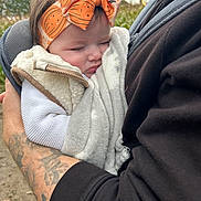Amelia is registered to the contest to win money with this photo: baby, sleeping, headband, orange, blanket, vest, tattoo, arm, person, outdoor, nature, tree, fall, closeup, cozy, child, infant, portrait, holding, warm