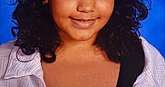 Dakota is registered to the contest to win money with this photo: black_top, blue_background, child, clothing, confident_expression, curly_hair, dark_hair, eyes, face, front_facing, headshot, indoor, looking_at_camera, person, photography, portrait, shoulders, smiling, studio, white_shirt