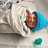 Jackson joined the competition — help win amazing prizes! newborn, baby, sleeping, infant, face, portrait, blue_hat, knitted_hat, blanket, swaddled, hospital_bedding, pacifier, medical_setting, nursery, lying_down, peaceful, indoors, textile, photography, cozy
