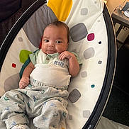 Jackson joined the competition — help win amazing prizes! baby, infant, child, portrait, smiling, happy, sitting, bouncer, baby_chair, indoor, clothing, outfit, patterned_blanket, polka_dots, colorful, face, eyes, brown_hair, furniture, home