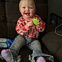 toddler, child, smiling, happy, sitting, couch, toy, jeans, socks, sweater, indoor, hair, face, clothing, furniture, person, cute, casual, playful, home