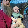 baby, man, beard, tattoo, cap, aquarium, fish, underwater_tunnel, water, blue, child, holding, curious, person, indoor, casual_clothing, bib, sneakers, wooden_floor, parent