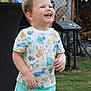 child, toddler, smiling, laughing, shorts, shirt, outdoor, grass, party, balloons, sound_equipment, happy, cute, summer, playful, fun, young, casual_clothing, daylight, celebration