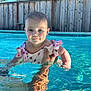 baby, child, swimming_pool, water, summer, outdoor, sunlight, reflection, polka_dot, swimsuit, cute, smiling, person, hand, skin, trees, fence, blue, daytime, recreation