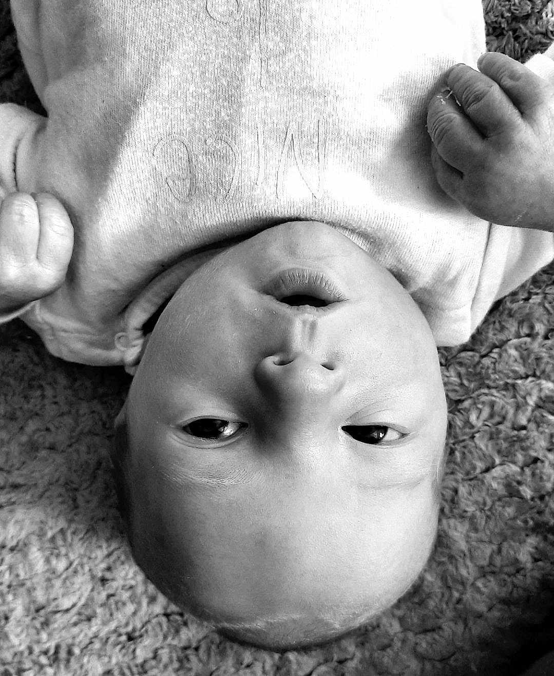 Lyam participe au concours pour gagner de l'argent avec cette photo : baby, infant, face, skin, eyes, mouth, hand, onesie, clothing, carpet, texture, black_and_white, portrait, close_up, newborn, child, human, expression, soft, lying_down