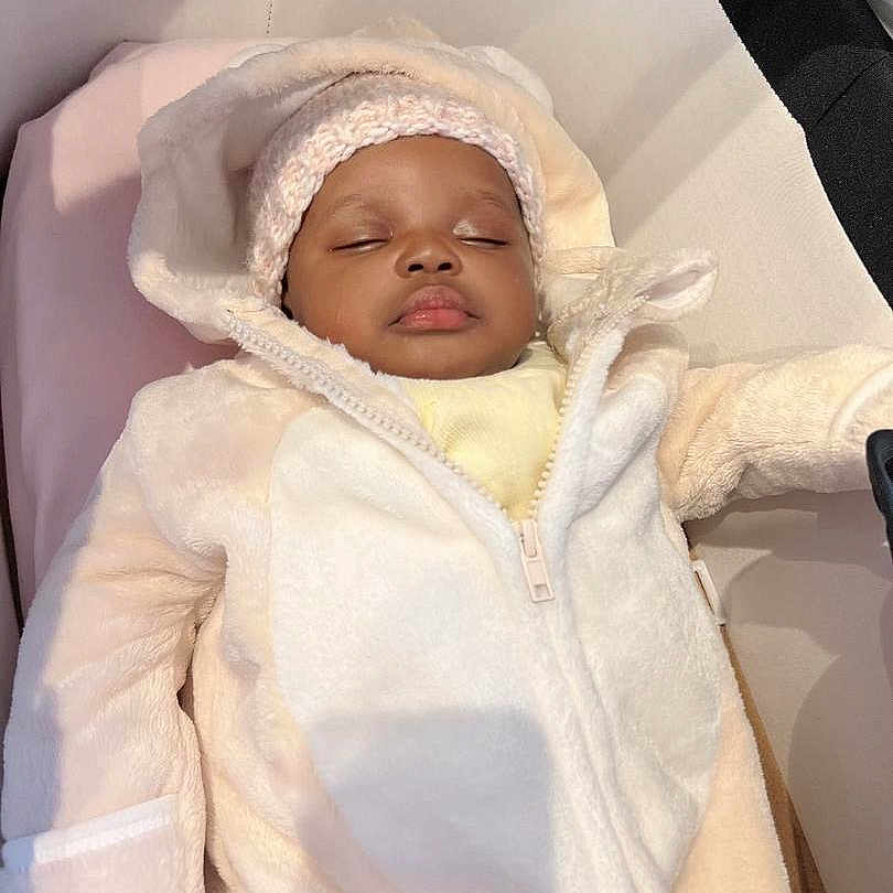 Gwendolyn joined the competition — help win amazing prizes! baby, blanket, bonnet, clothing, coat, crib, face, furniture, happy, hat, head, hood, infantbed, jacket, newborn, person, photography, portrait, sleeping, sleeve