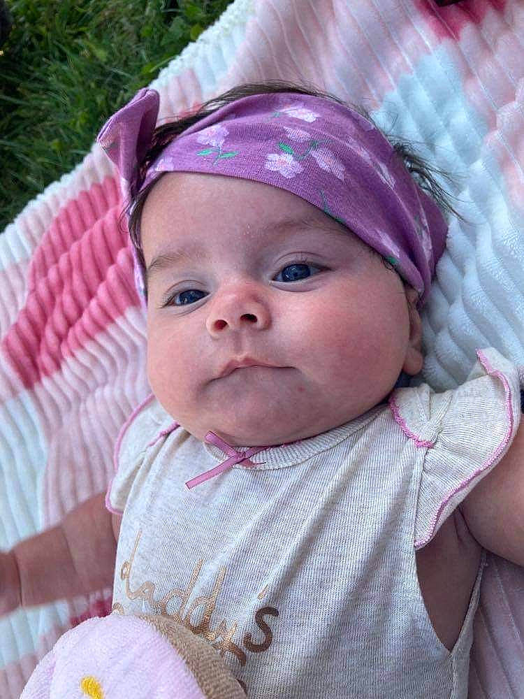 Ada-james is registered to the contest to win money with this photo: baby, baby_toddler_clothing, cheek, dress, eye, eyebrow, fun, grass, happy, head, headgear, headwear, iris, lip, nose, outerwear, person, pink, purple, skin