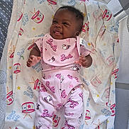 Crystal joined the competition — help win amazing prizes! baby, infant, child, portrait, lying_down, bassinet, blanket, pink_outfit, barbie, smiling, face, hands, feet, indoors, nursery, drum_pattern, stars, fabric, photography, cute