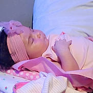 Bella is registered to the contest to win money with this photo: baby, sleeping, pink, headband, blanket, pillow, infant, resting, indoors, soft_fabric, cute, child, peaceful, young, toddler, cozy, clothing, face, skin, comfort