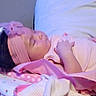 baby, sleeping, pink, headband, blanket, pillow, infant, resting, indoors, soft_fabric, cute, child, peaceful, young, toddler, cozy, clothing, face, skin, comfort