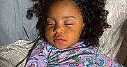 Nayla joined the competition — help win amazing prizes! bed, blanket, child, clothing, comfort, curly_hair, cute, face, hair, indoors, nap, pajamas, patterned, peaceful, person, relaxation, resting, sleeping, toddler, young_child