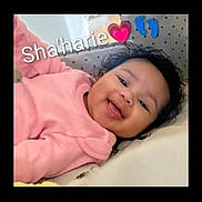 Shahari Jackson is registered to the contest to win money with this photo: baby, bed, child, curly_hair, cushion, cute, emoji, face, footprints, happy, head, heart, indoors, infant, lying_down, person, pink_clothing, portrait, smiling, text_overlay