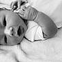 baby, black_and_white, blanket, clothing, cute, expression, face, hand, head, indoors, infant, lying_down, newborn, peaceful, portrait, skin, sleepwear, soft_texture, toddler, young_child