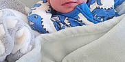 Ryder is registered to the contest to win money with this photo: baby, bed, blanket, child, comfort, cozy, cute, dinosaur_print, indoors, infant, newborn, onesie, peaceful, portrait, resting, sleeping, small, soft, toddler, warm