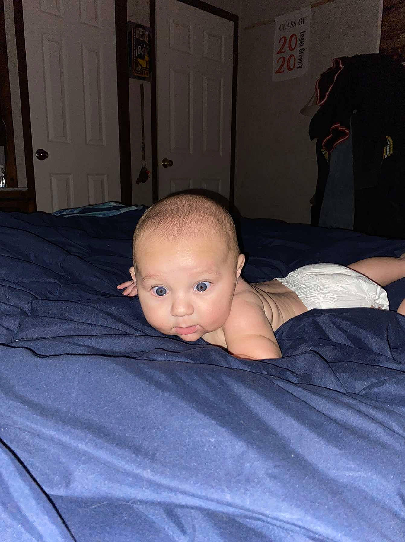 Corbyn is registered to the contest to win money with this photo: baby, baby_toddler_clothing, bedding, chest, child, comfort, crawling, door, eyebrow, flash_photography, floor, flooring, hardwood, linens, mammal, person, room, sitting, toddler, trunk