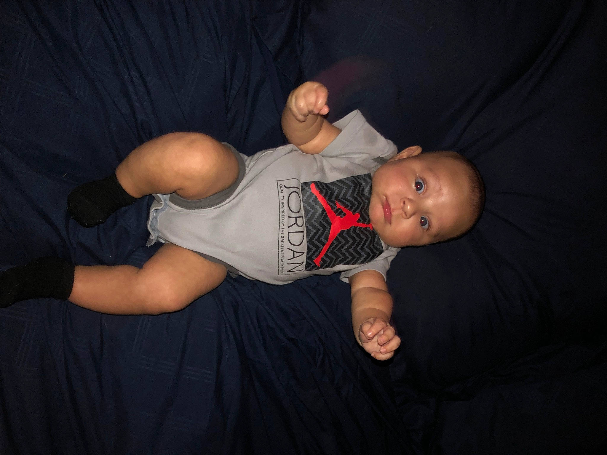 Corbyn is registered to the contest to win money with this photo: abdomen, baby, chest, elbow, entertainment, event, flash_photography, human_leg, knee, leg, performing_arts, person, recreation, shorts, sitting, sleeve, t_shirt, thigh, toddler, trunk