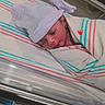 Tasneem joined the competition — help win amazing prizes! baby, bassinet, blanket, closed_eyes, cozy, face, hat, heart, hospital, indoors, infant, medical, newborn, nursery, peaceful, photography, portrait, sleeping, striped, swaddled
