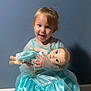 Londyn joined the competition — help win amazing prizes! blue_dress, blue_wall, carpet, child, cute, doll, dress, face, holding, indoor, person, playful, portrait, princess_costume, small_child, smiling, toddler, tongue_out, toy, young_child