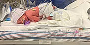 Londyn is registered to the contest to win money with this photo: adult, architecture, baby, bed, building, clinic, clothing, crib, doctor, furniture, glove, hospital, indoors, infantbed, male, man, medicalprocedure, newborn, operatingtheatre, person