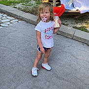 Londyn is registered to the contest to win money with this photo: blankets, child, concrete, cute, daylight, grass, milk_bottle, outdoor, pacifier, person, picnic_table, playtime, shorts, sneakers, standing, summer, toddler, towels, trees, white_tshirt