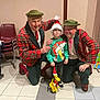 Jessy participe au concours pour gagner de l'argent avec cette photo : background, chair, child, christmas, clown, decor, floor_tiles, glasses, green_hat, holiday, indoor, person, plush_toy, red_plaid_jacket, santa_hat, shoes, smiling, sweater, toy