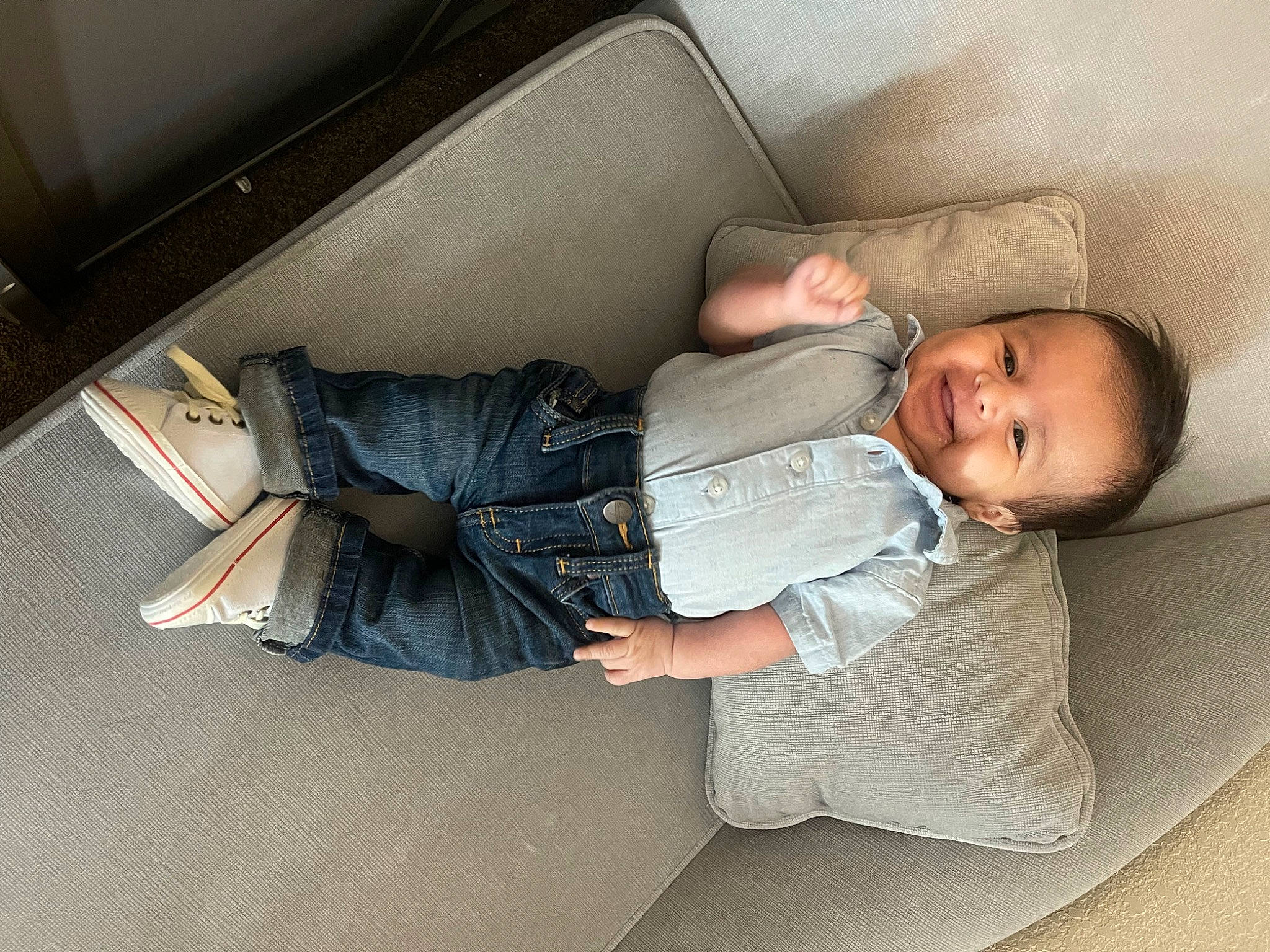 Juan is registered to the contest to win money with this photo: automotive_design, baby, baby_toddler_clothing, car_seat, comfort, finger, floor, flooring, hardwood, human_leg, lap, linens, person, room, sitting, smile, sock, textile, toddler, vehicle_door