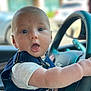 baby, bodypart, car, clothing, coat, face, finger, hand, head, jacket, machine, pants, person, photography, portrait, steeringwheel, transportation, vehicle, vest, wheel