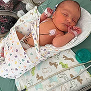 Dallas is registered to the contest to win money with this photo: newborn, baby, hospital, blanket, heart_pattern, pacifier, monitor, medical_tape, infant, sleeping, swaddled, dinosaur_pattern, bed, wire, cute, peaceful, patient, person, healthcare, resting