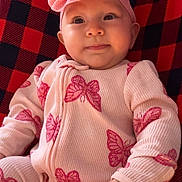 Everlee is registered to the contest to win money with this photo: baby, infant, child, onesie, pink, butterfly_pattern, headband, bow, red_and_black_blanket, blanket, cute, smiling, portrait, indoors, soft_texture, clothing, hand, face, happy, baby_girl