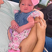 Paris is registered to the contest to win money with this photo: baby, infant, child, pink_bow, denim, dress, socks, hands, arms, person, clothing, cute, portrait, indoor, fabric, holding, newborn, soft, cozy, human