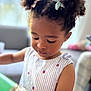 candid, child, closeup, curly_hair, cute, dress, focused, girl, hairstyle, holding, home, indoor, person, pigtails, playing, portrait, soft_light, striped_clothing, toddler, young_child
