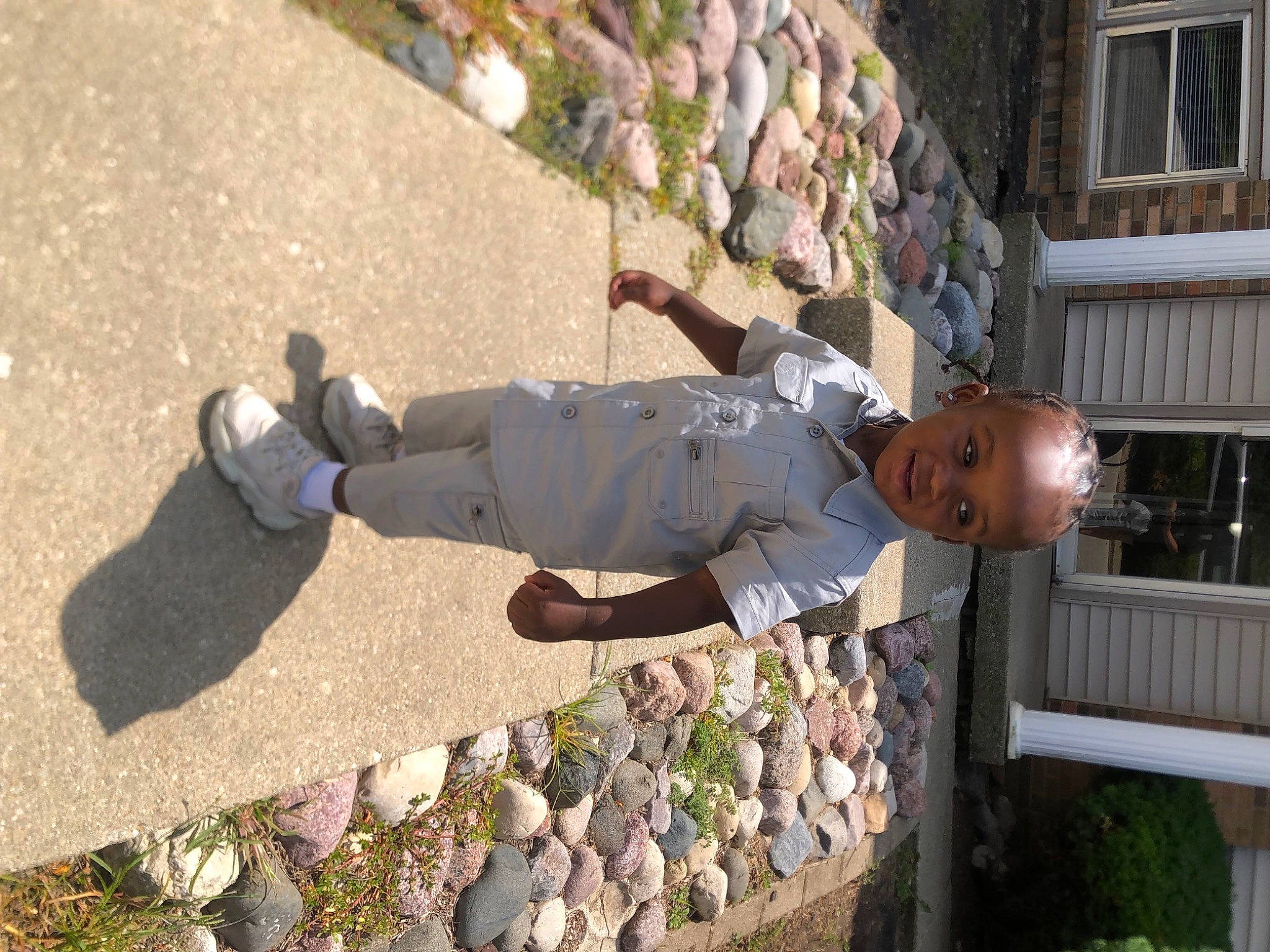 Dash is registered to the contest to win money with this photo: building, concrete, grass, leisure, people_in_nature, person, plant, recreation, road_surface, shadow, sidewalk, soil, toddler, tree, window, wood