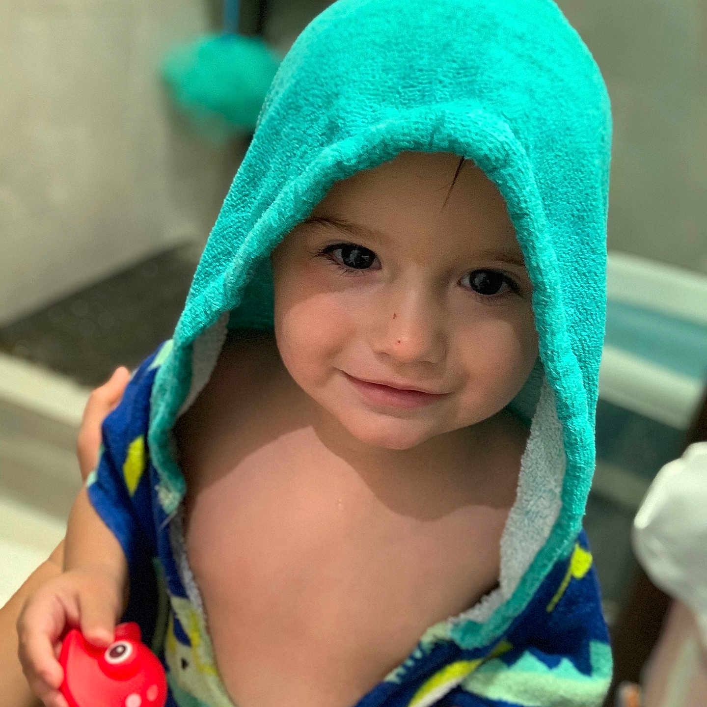 Gabriel a rejoint le concours — aidez-le/la à gagner de superbes lots ! bathroom, child, cute, face, fish_toy, hand, happy, hooded_towel, indoor, person, play, portrait, red_toy, skin, smile, toddler, towel, toy, water, young_child