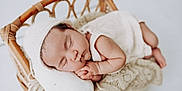 Sara is registered to the contest to win money with this photo: baby, sleeping, newborn, infant, knit_hat, white_clothing, wicker_basket, blanket, pillow, cozy, peaceful, cute, soft_texture, resting, portrait, indoors, child, toddler, hands, face