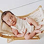 Sara is registered to the contest to win money with this photo: baby, sleeping, infant, knitwear, hammock, wooden_frame, pillow, white_background, peaceful, cute, resting, portrait, soft_lighting, newborn, child, minimalist, cozy, indoors, relaxing, tiny