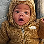 baby, brown_clothing, casual_wear, child, couch, cozy, cute, face, fuzzy_jacket, hood_with_ears, indoor, infant, person, portrait, soft_texture, surprised_expression, warm_clothing, wide_eyes, young_child, zipper
