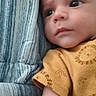 baby, child, infant, face, portrait, onesie, yellow_clothing, lying_down, blue_blanket, striped_blanket, expression, curious, skin, arm, head, young_child, indoors, closeup, person, sleepwear