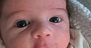 éden is registered to the contest to win money with this photo: baby, infant, face, close_up, eyes, blanket, cozy, curious, expression, newborn, skin, portrait, child, young, head, clothing, cute, indoors, soft_light, human