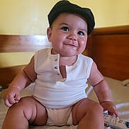 Abel a rejoint le concours — aidez-le/la à gagner de superbes lots ! baby, child, smile, cap, onesie, sitting, bed, cream_tube, skin, arm, leg, face, indoors, furniture, wood, happy, cute, infant, portrait, person