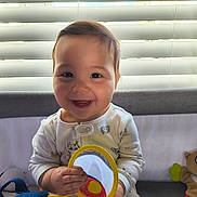 Mariana is registered to the contest to win money with this photo: baby, blinds, cheeks, crib, hands, happy, indoor, infant, mirror, nursery, onesie, playtime, plush_toy, portrait, sitting, smiling, sunlight, teeth, toy, window_blinds