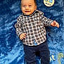 Arthur a rejoint le concours — aidez-le/la à gagner de superbes lots ! baby, child, smiling, plaid_shirt, navy_pants, blue_blanket, dinosaur, socks, infant, portrait, cute, lying_down, happy, clothing, soft_texture, indoor, person, five_months, sign, adorable