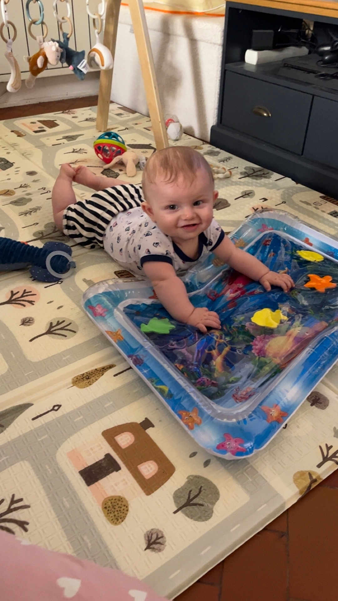 Kaïs a rejoint le concours — aidez-le/la à gagner de superbes lots ! baby, child, play_mat, toy, indoor, floor, infant, smiling, crawling, water_toy, colorful, soft_lighting, playtime, cute, home, furniture, floor_mat, animal_toys, person, happy