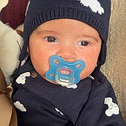 Ayden a rejoint le concours — aidez-le/la à gagner de superbes lots ! baby, blue_clothing, child, closeup, cloud_pattern, cozy, cute, eyes, face, hat, indoors, infant, knit_hat, pacifier, person, pom_pom, portrait, sitting, warm_clothing, young_child