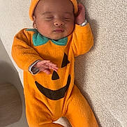 Ayden participe au concours pour gagner de l'argent avec cette photo : baby, infant, sleeping, pumpkin_costume, orange_clothing, hat, cute, child, costume, face, hand, footed_pajamas, indoors, resting, soft_texture, cozy, lying_down, peaceful, young_child, portrait