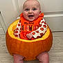 baby, pumpkin, halloween, orange, smile, child, holiday, costume, festive, cute, indoors, floor, door, celebration, happy, sitting, person, head, face, clothing