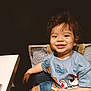 Ahyann-Mathïs a rejoint le concours — aidez-le/la à gagner de superbes lots ! blue_tshirt, bright, casual_clothing, chair, child, curly_hair, cute, denim_shorts, food, happy, indoor, patterned_chair, person, portrait, sitting, smiling, snack, table, toddler, young_child